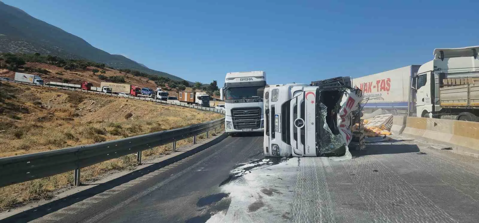 Devrilen tırdan onlarca çimento torbası yola savruldu