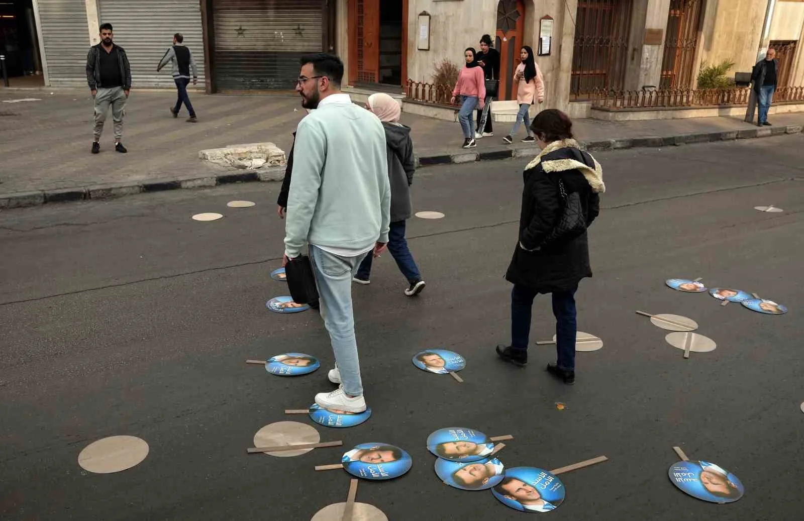 SURİYE'DE ESAD'IN FOTOĞRAFLARI ÇÖPLERE ATILDI, SOKAKLARA SAVRULAN POSTERLER HALKIN AYAKLARI